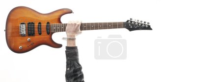 Foto de Rock star raising arm and showing his electric guitar, music and concerts concept - Imagen libre de derechos