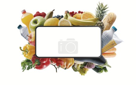 Foto de Fresh groceries and smartphone with blank screen, online shopping concept, isolated on white background - Imagen libre de derechos