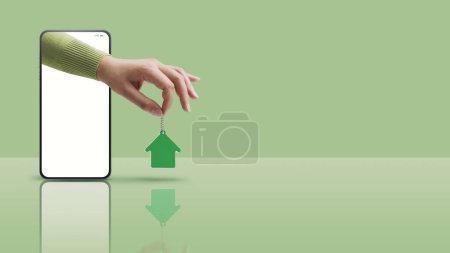 Téléchargez les photos : Real estate agent hand in a smartphone screen holding your new house keys, real estate app concept, copy space - en image libre de droit