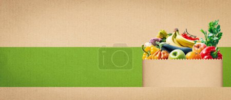 Foto de Grocery shopping bag full of fresh organic vegetables and fruits, grocery and healthy food concept, banner with copy space - Imagen libre de derechos