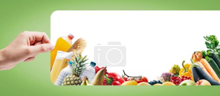 Photo for Hand holding a sign and assortment of fresh groceries, supermarket sale and grocery shopping concept - Royalty Free Image