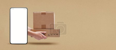 Foto de Manos sosteniendo cajas de cartón y teléfono inteligente con pantalla en blanco, concepto de aplicación de servicio de entrega urgente - Imagen libre de derechos