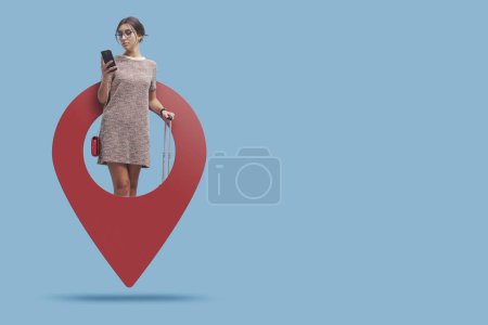 Photo for Young traveling woman in a GPS pin using her smartphone and booking services, travel and tourism concept - Royalty Free Image