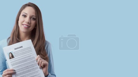 Téléchargez les photos : Jeune femme souriante tenant son CV et postulant pour un emploi - en image libre de droit