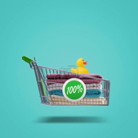 Photo for Colorful bath towels and rubber duck in a flying shopping cart, household items and shopping concept - Royalty Free Image