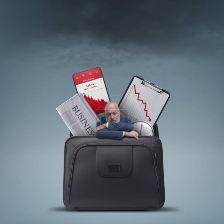 Téléchargez les photos : Stressed sad businessman and financial graphs showing loss in a briefcase, financial failure concept - en image libre de droit