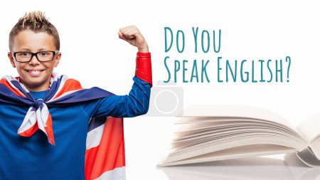 Téléchargez les photos : Joyeux élève super-héros apprenant l'anglais à l'école et livre ouvert - en image libre de droit