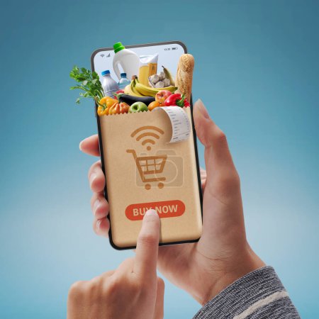 Foto de Online grocery shopping app: customer holding a smartphone and ordering groceries online - Imagen libre de derechos