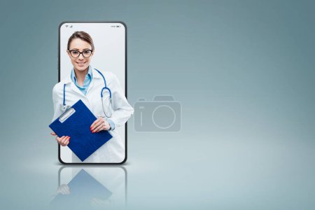 Foto de Mujer profesional médico en un videocall smartphone y sonriente, médico en línea y concepto de servicio de telemedicina - Imagen libre de derechos
