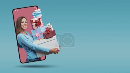 Photo for Happy smiling woman shopping and holding a lot of gift boxes  in a smartphone videocall and smiling, online  shopping concept - Royalty Free Image