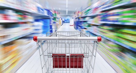 Foto de Empty shopping cart in the supermarket aisle, grocery shopping and retail concept, POV shot - Imagen libre de derechos