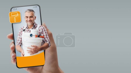Photo for Professional painter on smartphone screen: hire professionals online - Royalty Free Image