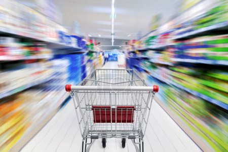 Foto de Carrito de compras vacío en el pasillo del supermercado, compras de comestibles y concepto de venta al por menor, POV shot - Imagen libre de derechos