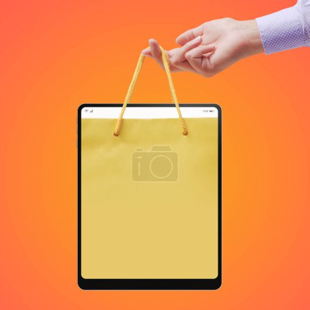 Téléchargez les photos : Femme tenant un sac à provisions dans une tablette numérique, concept d'achat et de vente en ligne - en image libre de droit