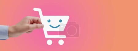 Photo for Woman holding a smiling shopping cart icon, online shopping concept - Royalty Free Image