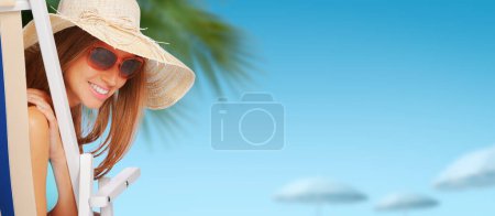 Foto de Hermosa mujer feliz sentado en una tumbona en la playa y tomar el sol, vacaciones de verano y el concepto de ocio, espacio de copia - Imagen libre de derechos