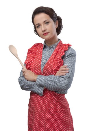 Foto de Atractiva ama de casa de antaño en delantal con una cuchara de madera - Imagen libre de derechos