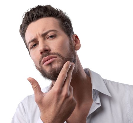 Photo for Young handsome man checking his face skin and touching his beard - Royalty Free Image