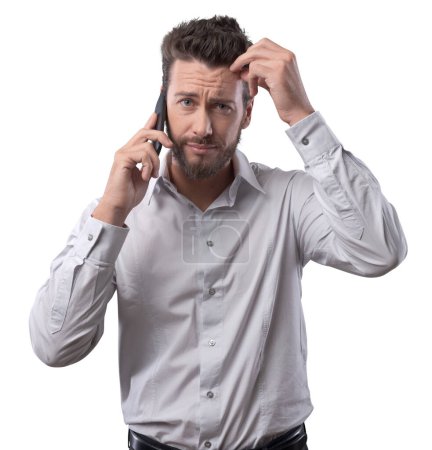 Photo for Disappointed confused young man on the phone having a call - Royalty Free Image