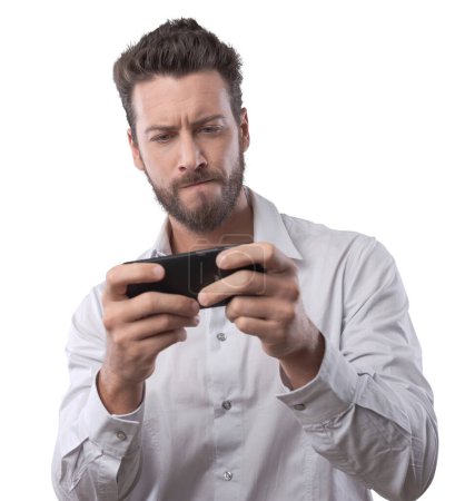 Foto de Joven guapo jugando con su teléfono inteligente sobre fondo blanco - Imagen libre de derechos
