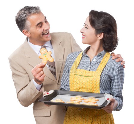 Photo for Vintage woman serving home made gingerbread men cookies to her smiling husband - Royalty Free Image