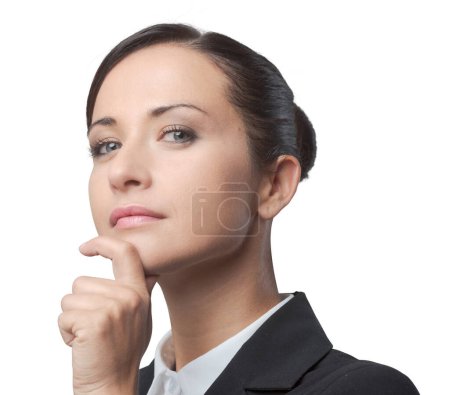 Téléchargez les photos : Charmante femme gestionnaire confiante avec la main sur le menton posant sur fond gris
. - en image libre de droit