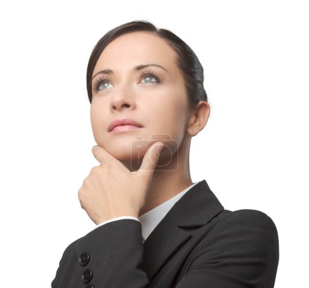 Foto de Atractiva mujer de negocios pensativa con la mano en la barbilla mirando hacia otro lado. - Imagen libre de derechos