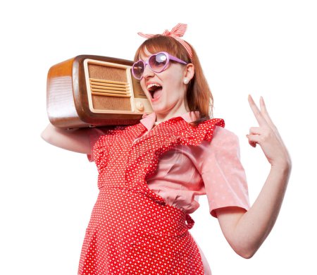 Téléchargez les photos : Femme drôle de style rétro portant une radio vintage sur son épaule et écoutant de la musique, elle danse et chante - en image libre de droit