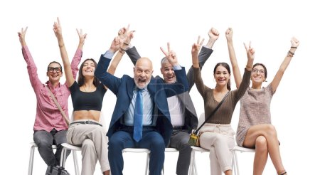Foto de Gente feliz y exitosa sentada en una silla y celebrando con los brazos levantados - Imagen libre de derechos