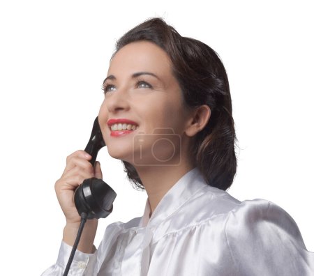 Photo for Attractive elegant vintage secretary having a phone call and smiling - Royalty Free Image