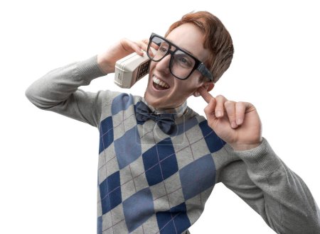 Photo for Funny nerd guy with big glasses having a phone call with a cordless telephone - Royalty Free Image