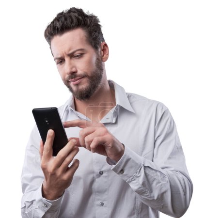 Photo for Disappointed young man typing on his touch screen smartphone - Royalty Free Image