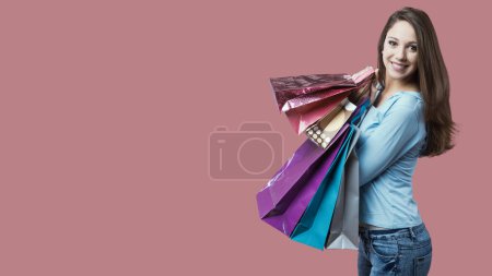 Photo for Cheerful smiling woman shopping with lots of colorful bags - Royalty Free Image