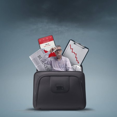 Téléchargez les photos : Stressed sad businessman and financial graphs showing loss in a briefcase, financial failure concept - en image libre de droit
