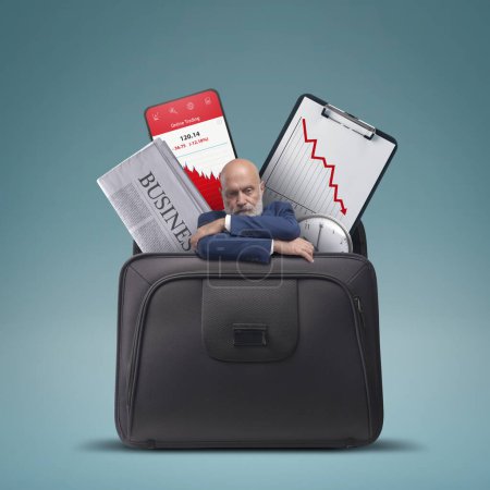 Foto de Estresado empresario triste y gráficos financieros que muestran la pérdida en un maletín, concepto de fracaso financiero - Imagen libre de derechos