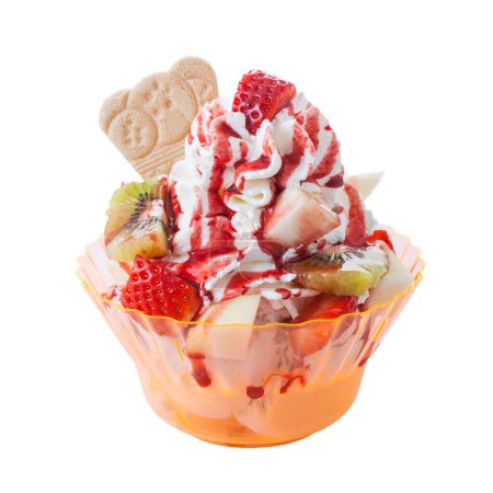 Foto de Delicioso helado de frutas con oblea y aderezos en una taza de plástico - Imagen libre de derechos