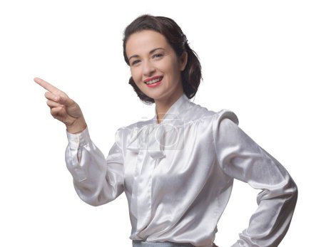 Foto de Atractiva mujer vintage en camisa elegante apuntando hacia arriba y sonriendo - Imagen libre de derechos