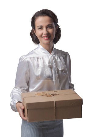 Téléchargez les photos : Femme vintage souriante tenant un colis postal, concept d'expédition et de livraison - en image libre de droit