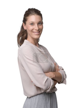 Foto de Mujer joven sonriente con una camisa elegante y posando con los brazos cruzados, ella sonríe a la cámara - Imagen libre de derechos