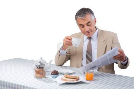 Foto de Elegante hombre de negocios que tiene un nutriente delicioso desayuno y periódico de lectura - Imagen libre de derechos