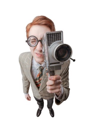 Foto de Divertido chico nerd sosteniendo una cámara de vídeo vintage y filmando un video - Imagen libre de derechos