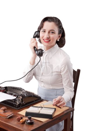 Foto de Hermosa secretaria sonriente sentada en el escritorio y respondiendo llamadas telefónicas, estilo vintage - Imagen libre de derechos