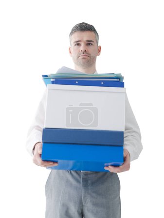 Téléchargez les photos : Homme d'affaires confiant portant des boîtes et de la paperasse dans le bureau - en image libre de droit