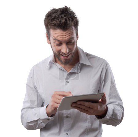 Téléchargez les photos : Joyeux homme excité recevant de bonnes nouvelles sur sa tablette - en image libre de droit