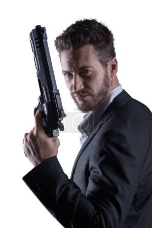 Foto de Valiente hombre fresco sosteniendo un arma peligrosa sobre fondo blanco - Imagen libre de derechos