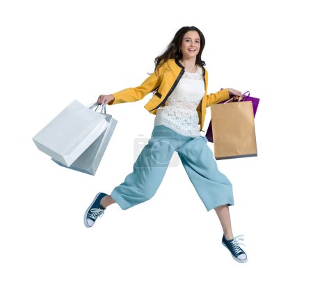 Téléchargez les photos : Joyeux femme heureuse qui aime faire du shopping : elle porte des sacs à provisions et court pour obtenir les dernières offres au centre commercial - en image libre de droit