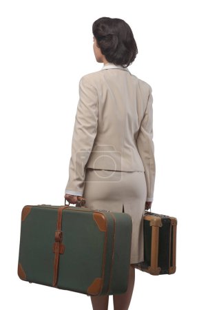 Photo for Attractive 1950s style woman holding suitcases rear view. - Royalty Free Image