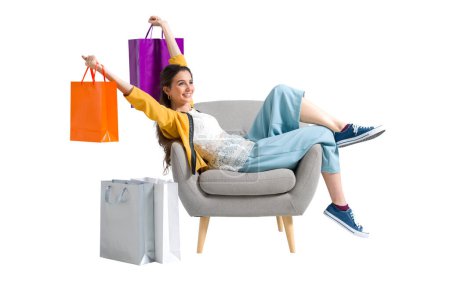 Foto de Alegre feliz shopaholic mujer con un montón de bolsas de compras, ella está sentado en un sillón y celebrando con los brazos levantados - Imagen libre de derechos
