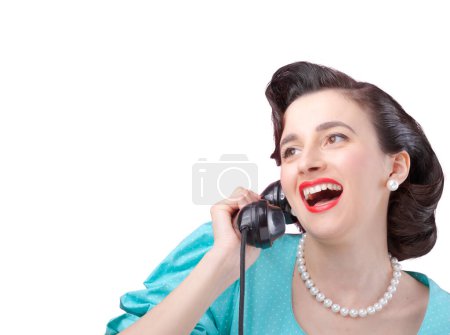 Foto de Alegre estilo vintage elegante mujer que tiene una emocionante llamada telefónica y chismes con su amigo, ella está sosteniendo el receptor y sonriendo - Imagen libre de derechos