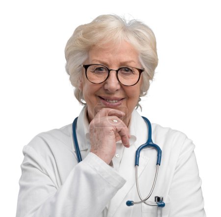 Téléchargez les photos : Senior confiant médecin féminin posant avec la main sur le menton sur fond gris et souriant à la caméra - en image libre de droit
